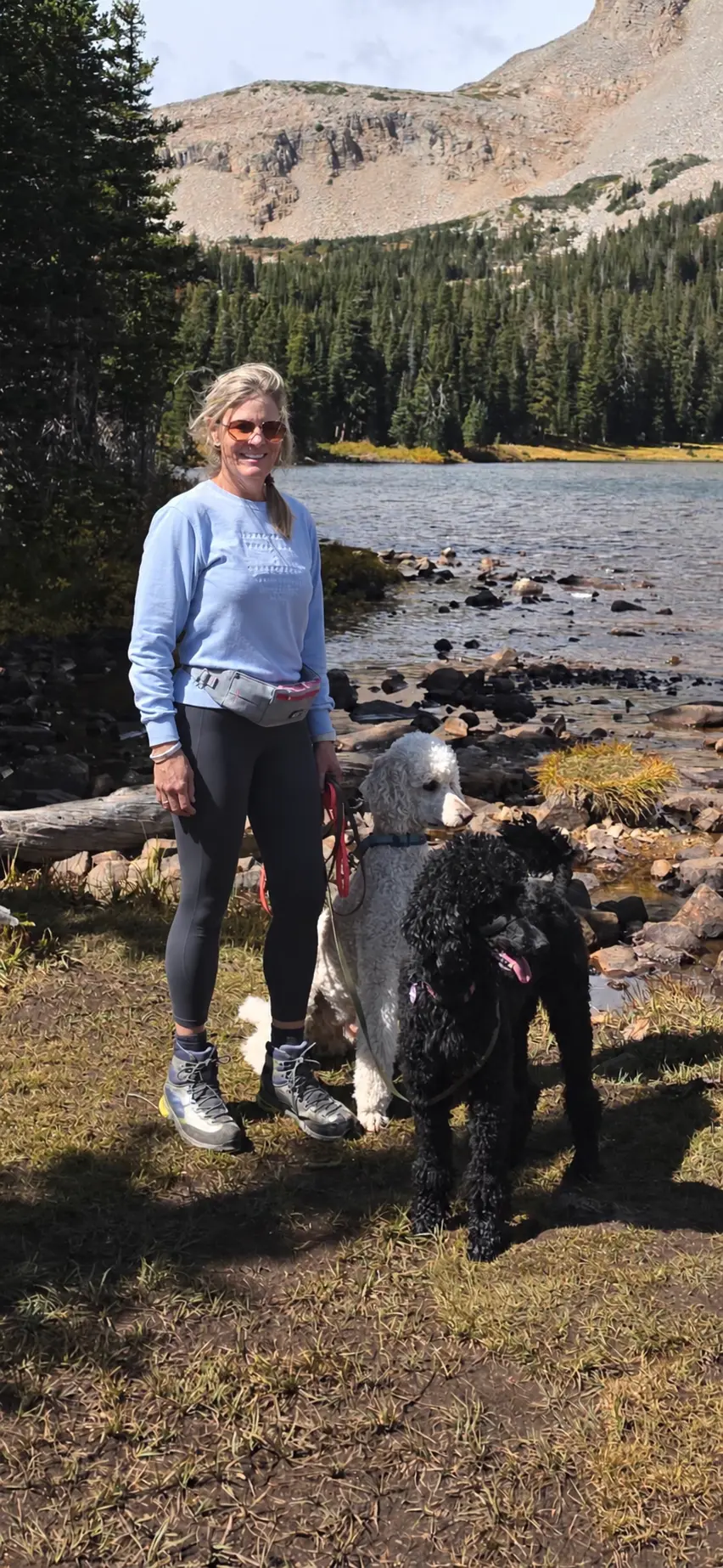 Tish Mason with her Standard Poodles beside a Colorado mountain lake
