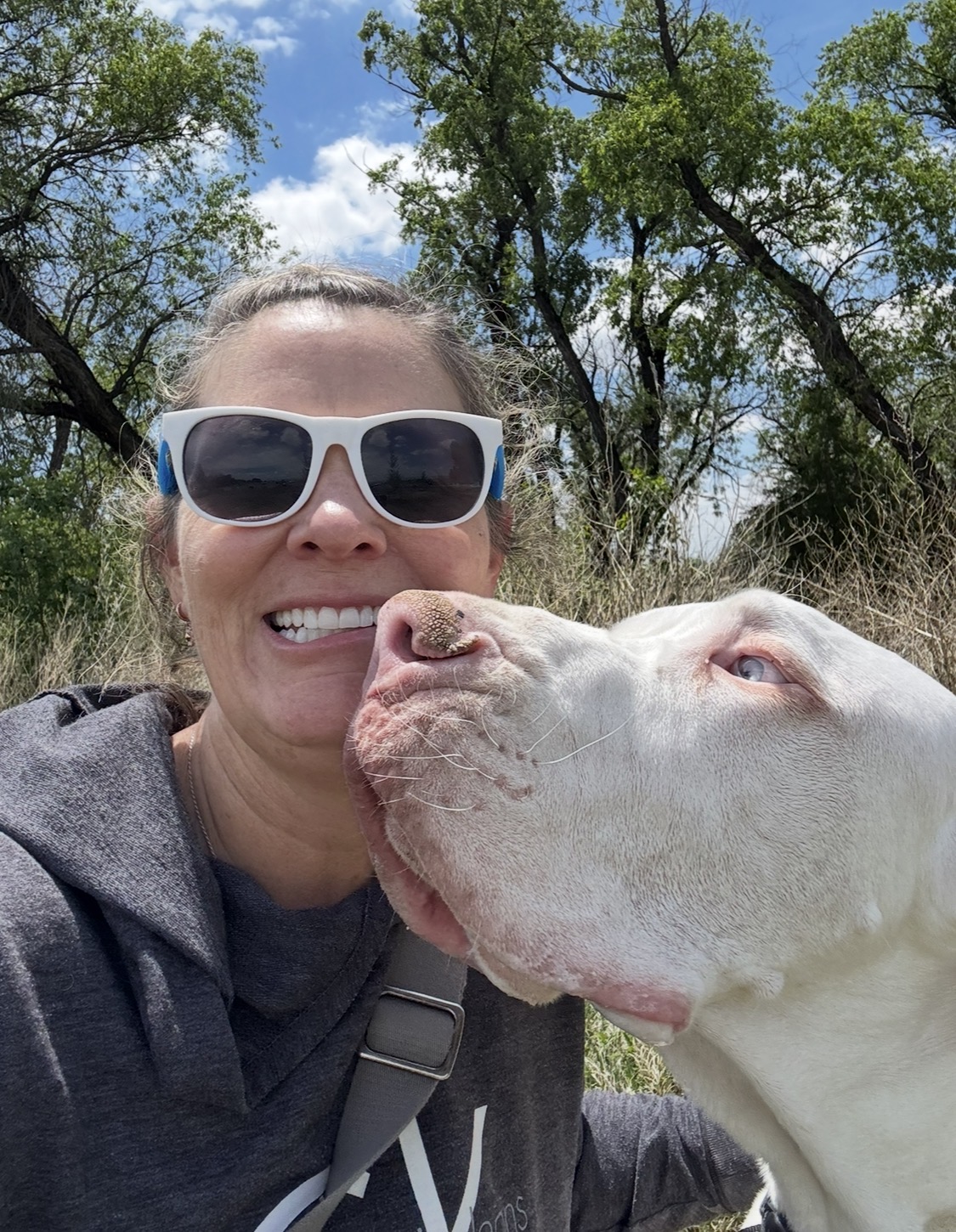 Tish smiling in a selfie with a white Great Dane